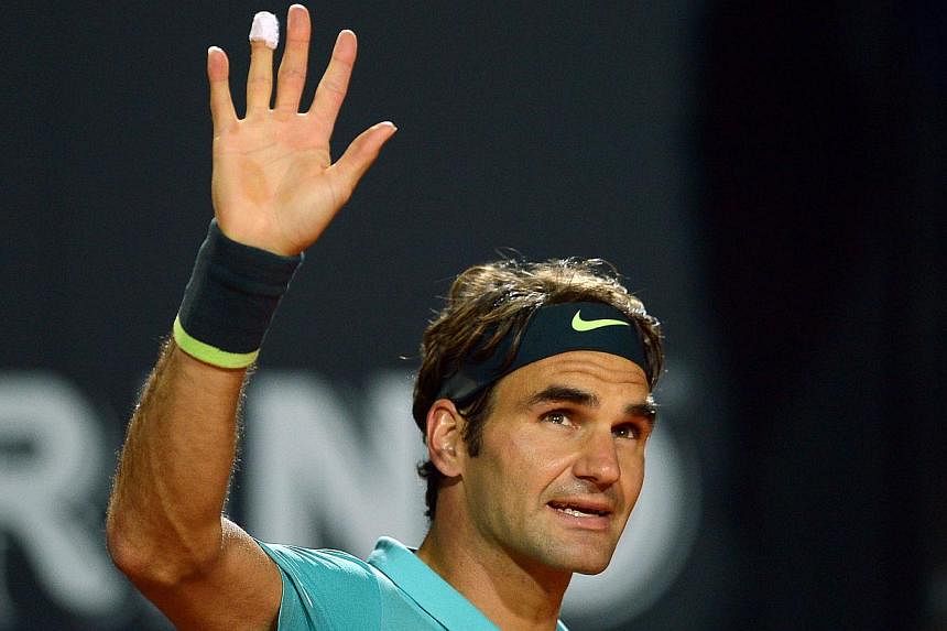 Roger Federer of Switzerland waves after beating compatriot Stan Wawrinka during their Italian Open semi-final match on May 16, 2015 in Rome. -- PHOTO: AFP