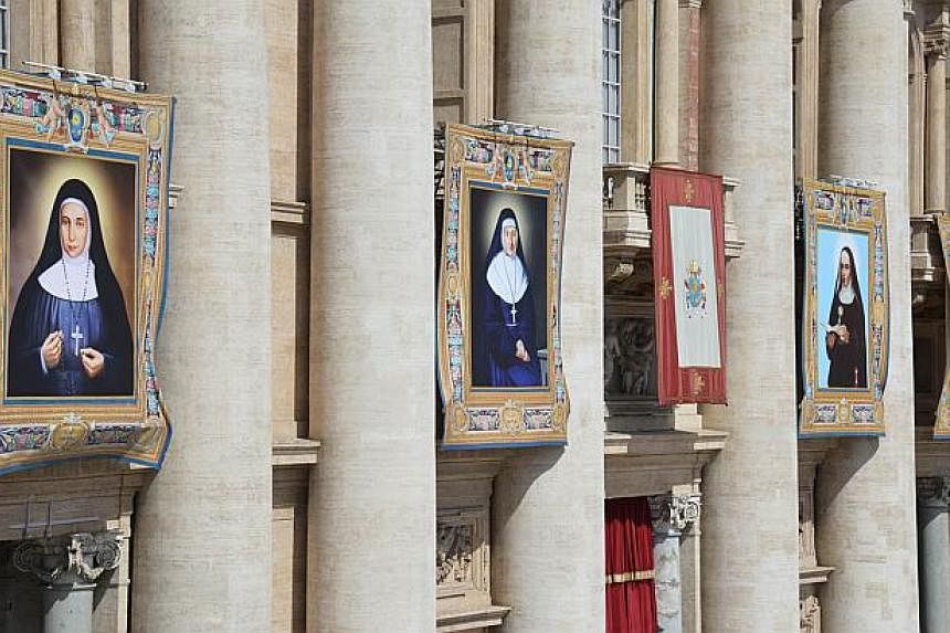A picture shows tapestries of four blessed nuns (from left) St Marie-Alphonsine Danil Ghattas, St Emilie de Villeneuve, St Maria Cristina of the Immaculate Conception and St Maryam Baouardy&nbsp;on the facade of St Peter's basilica during a papal mas