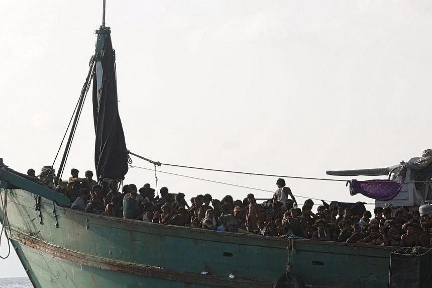 Migrants are seen aboard a boat tethered to a Thai navy vessel, in waters near Koh Lipe island, on May 16, 2015.&nbsp;&nbsp;-- PHOTO: REUTERS