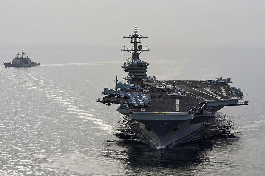 American aircraft carrier USS Theodore Roosevelt and guided-missile cruiser USS Normandy sail in the Gulf on April 16, 2015, supporting strike operations in Iraq and Syria as directed.&nbsp;At least 32 Islamic State in Iraq and Syria (ISIS) members, 