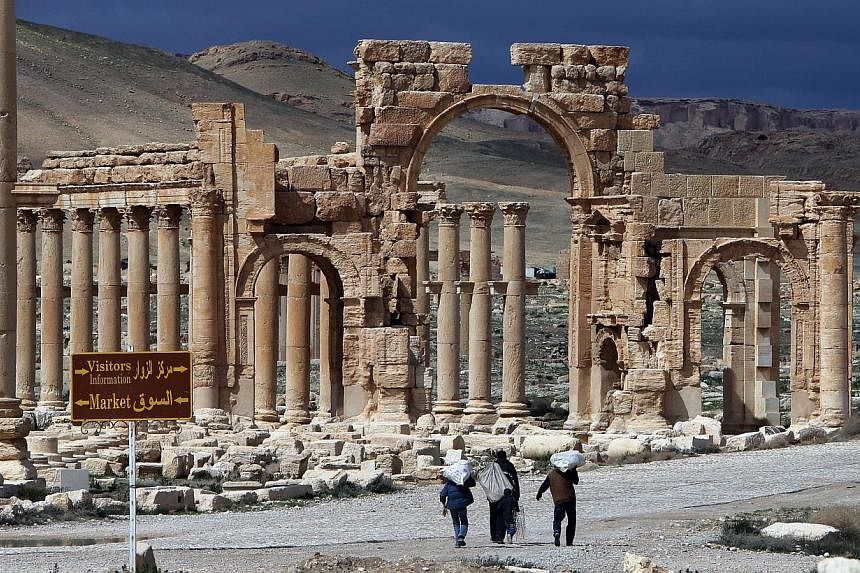 A file picture taken in March 2014 shows Syrian citizens walking in the ancient oasis city of Palmyra, 215km north-east of Damascus. -- PHOTO: AFP