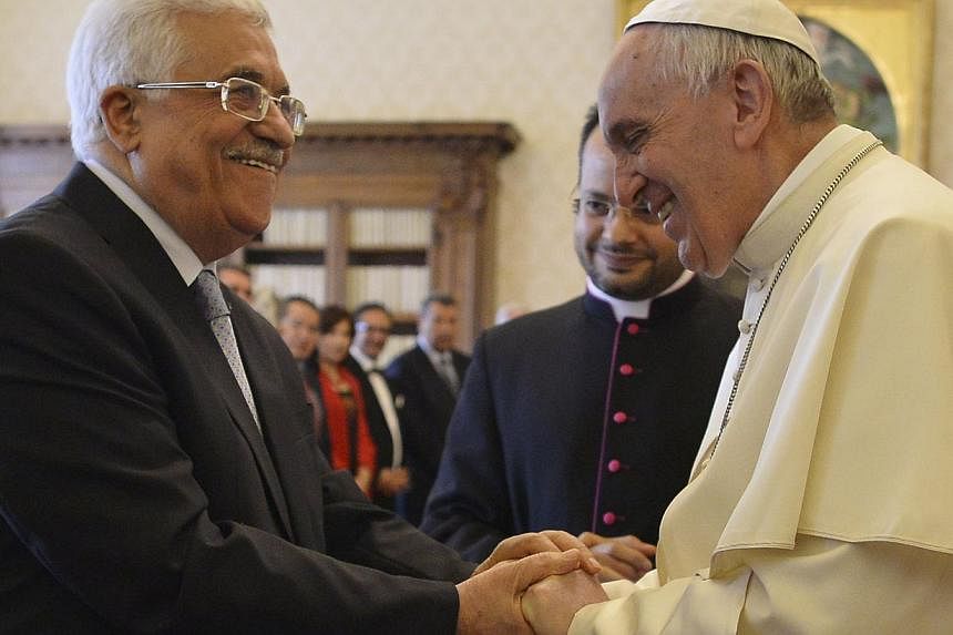 Pope Francis (right) shakes hands with Palestinian President Mahmoud Abbas during a private audience at the Vatican City, May 16, 2015. -- PHOTO: REUTERS