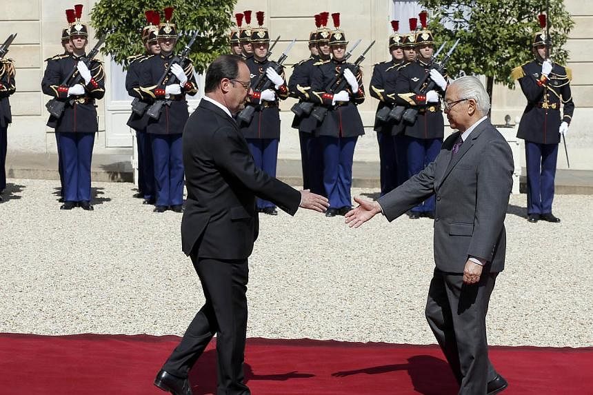Singapore's President Tony Tan Keng Yam (right) shakes hands with French President Francois Hollande at the Elysee Palace in Paris on May 18, 2015. -- PHOTO: AFP