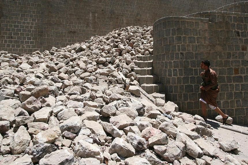 A Houthi militant walks by rubble of a part of the Qahira fort following air strikes in Yemen's south-western city of Taiz on May 12, 2015. -- PHOTO: REUTERS&nbsp;
