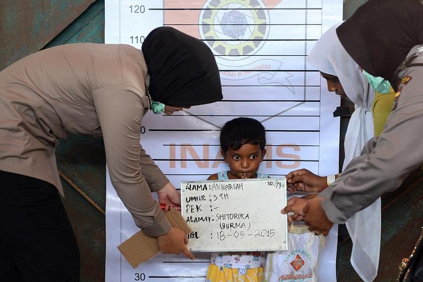 A Rohingya boy from Myanmar is photographed during an Indonesian police identification process at the confinement area in the fishing port of Kuala Langsa in Aceh province on May 18, 2015. -- PHOTO: AFP&nbsp;