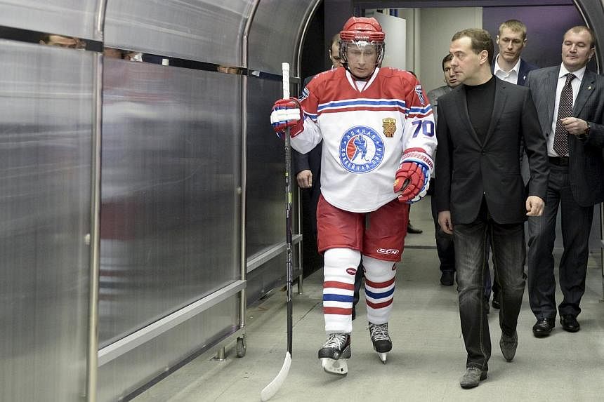 Russian Prime Minister Dmitry Medvedev (centre) speaking with President Vladimir Putin (left) during a gala match of the National Amateur Ice Hockey Teams' Festival organised by the Night Ice Hockey League in Sochi, Russia, on May 16, 2015. -- PHOTO: