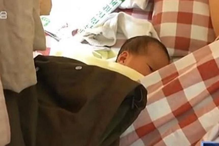 The baby girl in a hospital with her mother. She was born in the toilet of an Internet cafe in&nbsp;Nanchang, Jiangxi province, on May 11, 2015. -- PHOTO: SCREENGRAB FROM YOUKU.COM