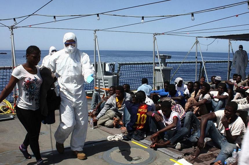 Migrants sit on board the German Navy frigate Hessen at sea in the Mediterranea off the Libyan coast, on May 14, 2015.&nbsp;European Union (EU) ministers are set to approve plans on Monday, May 18, for an unprecedented naval force to fight people smu