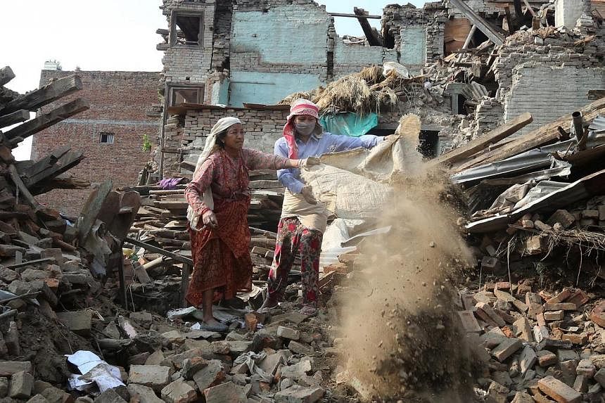 Nepalese earthquake survivors clear the rubble as they salvage belongings from a damaged house in devastated area of Bhaktapur, on the outskirts of Kathmandu, Nepal, on May 18, 2015.&nbsp;Nepal on Monday imposed a two-month moratorium on the start of