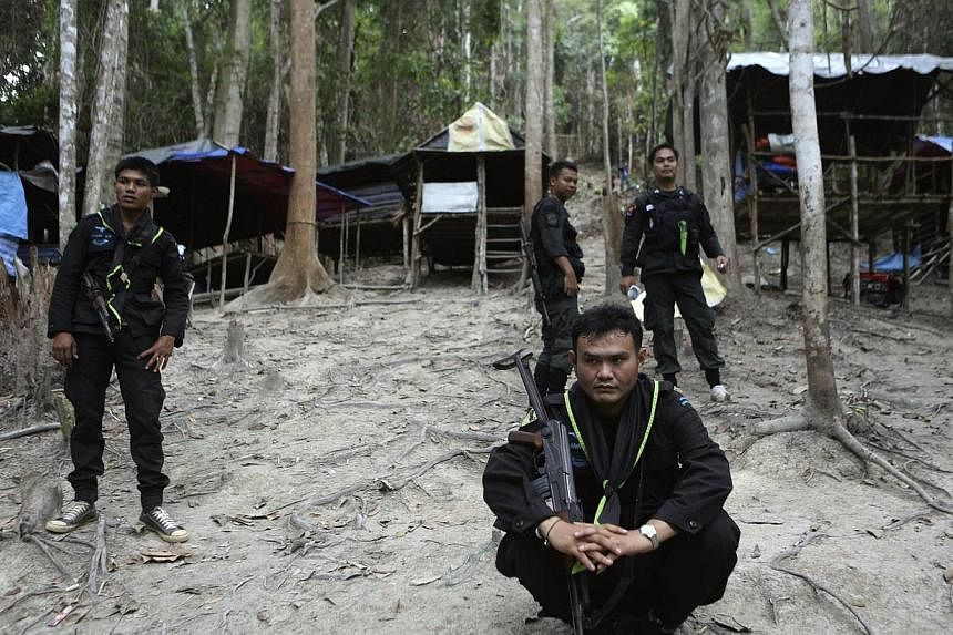 Thai soldiers secure the area next to shelters after discovering another abandoned jungle camp believed used by the human traffickers to detain Rohingya migrants at a mountain in Sadao, Thai-Malaysian border district, Songkhla province, southern Thai