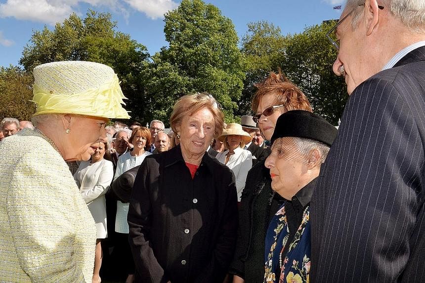 Britain's Queen Elizabeth II (left) talks to Holocaust survivors (left to right) Susan Pollock, her daughter Sandra Gee, Cirla Lewis, also a survivor and her husband Phillip Lewis during a garden party held at Buckingham Palace, in London on May 12. 