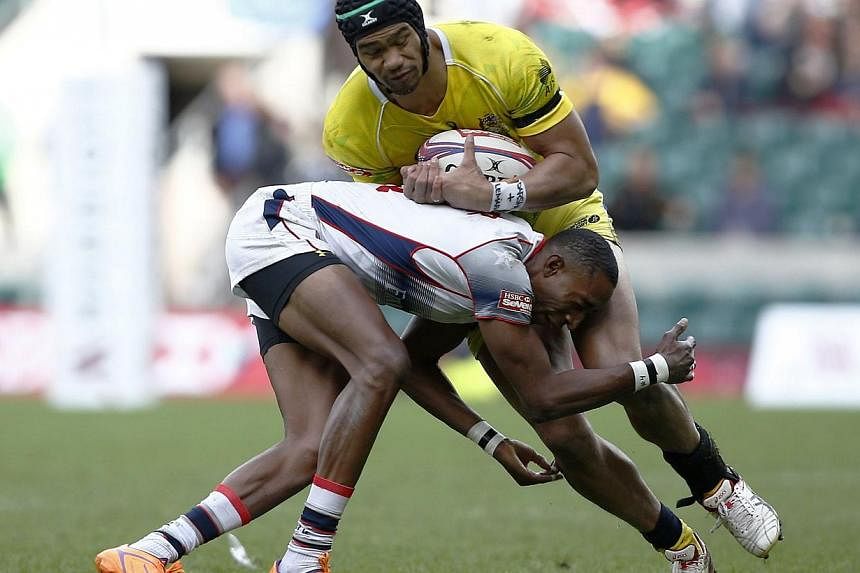 &nbsp;Perry Baker (left) of the United States tackles Australia's Pama Fou during the London Sevens rugby union cup final match between USA and Australia, part of the IRB Sevens World Series, at Twickenham Stadium in London on Sunday. -- PHOTO: AFP