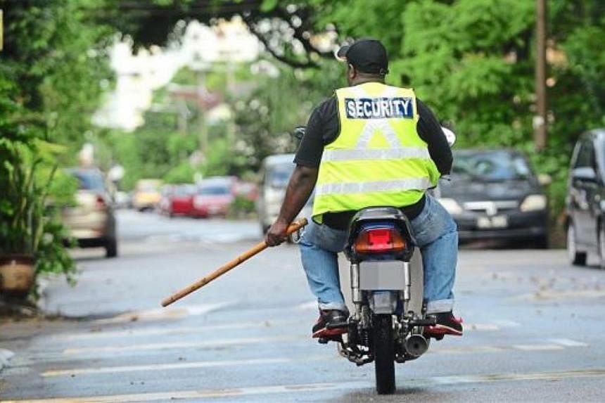 A motorcycle-riding security guard patrolling a neighbourhood street in Malaysia. -- PHOTO: THE STAR/ASIA NEWS NETWORK