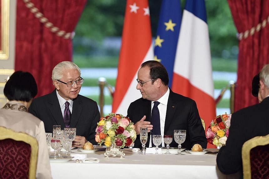 French president Francois Hollande (centre, right) speaking with President Tony Tan Keng Yam (centre, left) during an official dinner in his honour at the Elysee presidential Palace in Paris, France on May 18, 2015. -- PHOTO: EPA&nbsp;