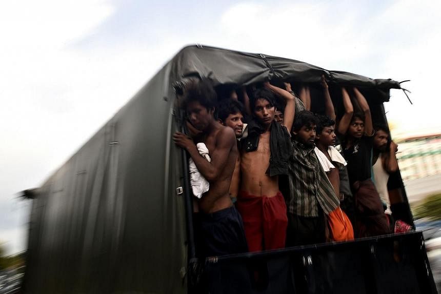 Bangladeshi migrants standing in a moving police van at the police headquarters in Langkawi on May 11, 2015. -- PHOTO: AFP&nbsp;