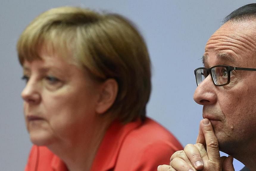 German Chancellor Angela Merkel (left) and French President Francois Hollande attend the Petersberg Climate Dialogue conference in Berlin, Germany on&nbsp;May 19, 2015. -- PHOTO: REUTERS
