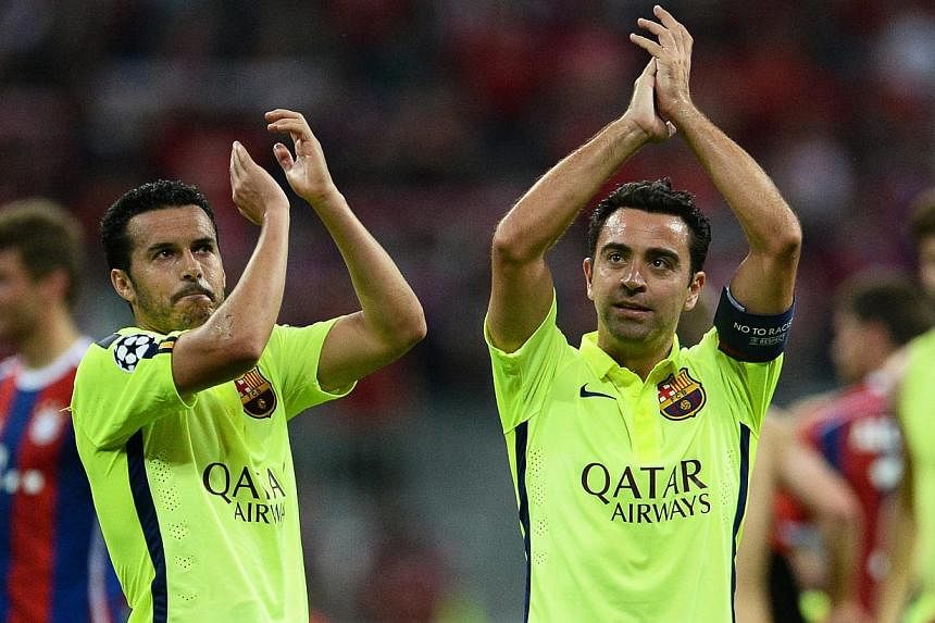 FC Barcelona players Xavi Hernandez (right) and Pedro Rodriguez (left) applaud supporters after the UEFA Champions League semi final second leg&nbsp;football match between FC Bayern Munich and FC Barcelona in Munich, Germany on May 12, 2015. -- PHOTO
