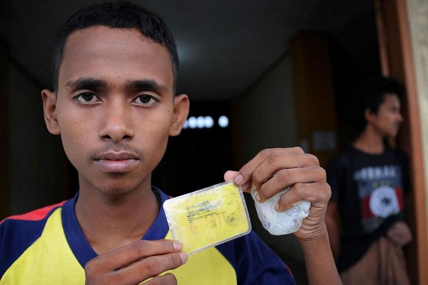 Muhammad Shorif, 16, showing his identification card after coming ashore in Indonesia on May 12, 2015. The teenager's story of attempting to flee poverty by embarking on a perilous sea voyage illustrates the torment and dreams driving Asia's migrant 