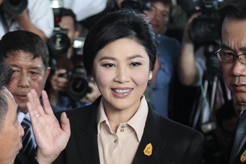 Thailand's ousted prime minister Yingluck Shinawatra (centre) greeting well-wishers and supporters as she arrives at the Supreme Court to face charges of corruption over a rice subsidy plan, in Bangkok, on May 19, 2015. -- PHOTO: EPA&nbsp;
