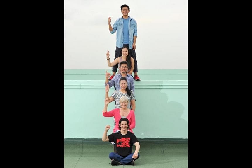 Cast of Tribes spelling the play’s title by sign language: (from top) Thomas Pang, Ethel Yap, Adrian Pang, Frances Lee, Susan Tordoff and Gavin Yap. -- PHOTO: LIM YAOHUI FOR THE STRAITS TIMES