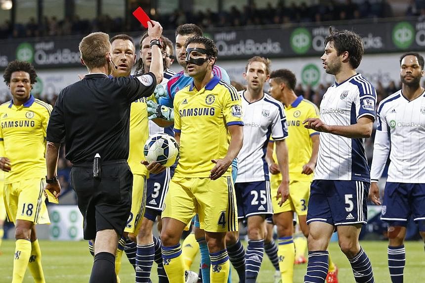 Chelsea midfielder Cesc Fabregas (in mask) being shown a red card by referee Mike Jones during his team's 3-0 defeat to West Brom. -- PHOTO: REUTERS&nbsp;