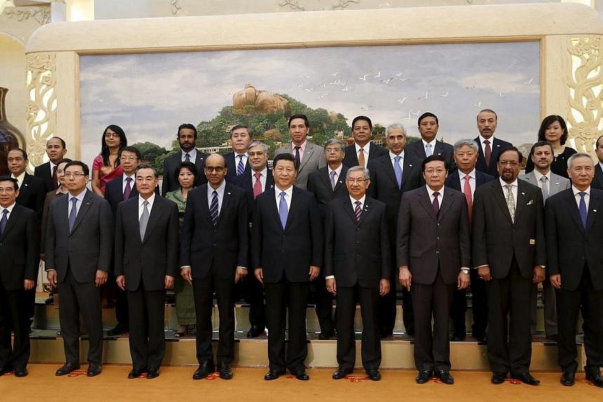 China's President Xi Jinping (centre) posing for photos with guests at the Asian Infrastructure Investment Bank launch ceremony at the Great Hall of the People in Beijing, on Oct 24, 2014. -- PHOTO: REUTERS