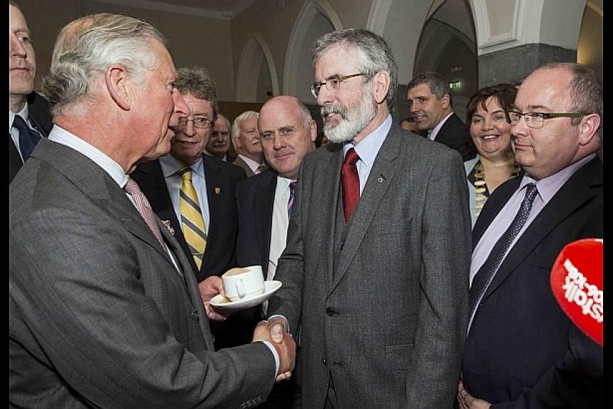 Britain's Prince Charles (left) shakes hands with Gerry Adams at the National University of Ireland in Galway, Ireland on Tuesday. -- PHOTO:&nbsp;REUTERS