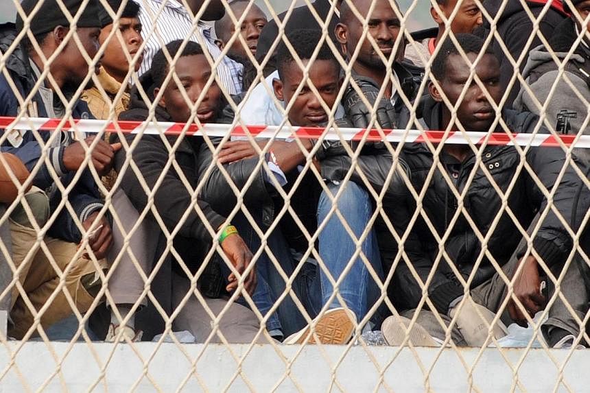 Migrants wait to disembark from military ship "Bettica" following a rescue operation at sea on May 5 in the port of Salerno in southern Italy.-- PHOTO: AFP&nbsp;