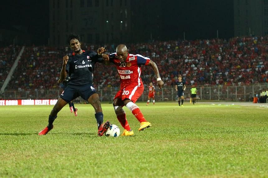 LionsXII defender Madhu Mohana (left) and Kelantan striker Emmanuel Kenmogne. The LionsXII will face Kelantan in what will be a highly-anticipated Malaysian FA Cup final at the Bukit Jalil Stadium in Kuala Lumpur this Saturday, and a state public hol