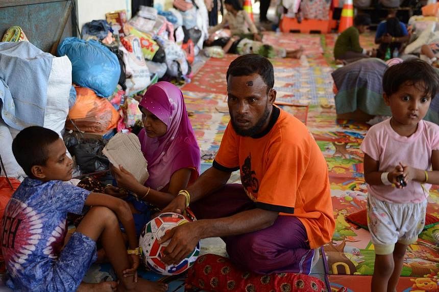 Rescued Rohingya migrant from Myanmar, Mohammad Amih (C), sits with other survivors at the port in Langsa in Aceh. A vicious fight among Rohingya and Bangladeshi migrants on board a foundering vessel off Indonesia left at least 100 dead, survivors sa