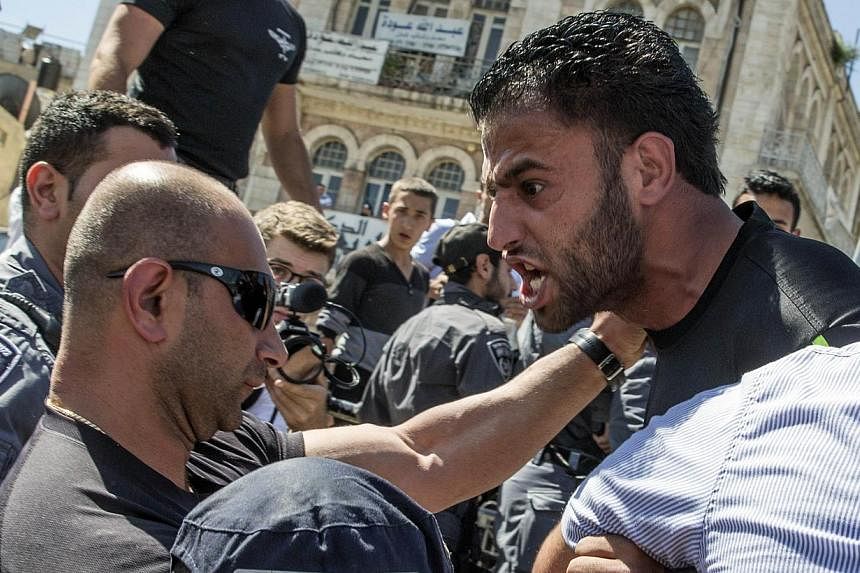 Palestinian demonstrators are confronted by Israeli police during the Israeli "flag march" through Damascus Gate in Jerusalem's old city during celebrations for Jerusalem Day on May 17, 2015. Two Israeli policemen were wounded in annexed east Jerusal