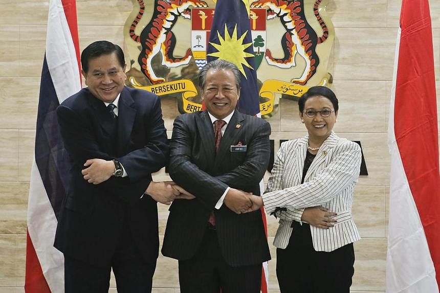 Ministers of Foreign Affairs from Thailand, Mr Tanasak Patimapragorn (left), Malaysia,&nbsp;Datuk Seri Anifah Aman (centre), and Indonesia, Ms Retno Marsudi (right) holding hands during a meeting on human trafficking and people smuggling in Putrajaya