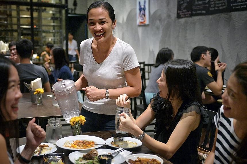 Ms Jackie Condat interacting with patrons at Bukit Timah eatery Little Diner. For her, little things like getting to know patrons by name and writing them personalised birthday notes should be part of the job. She says: "You want to make them feel li