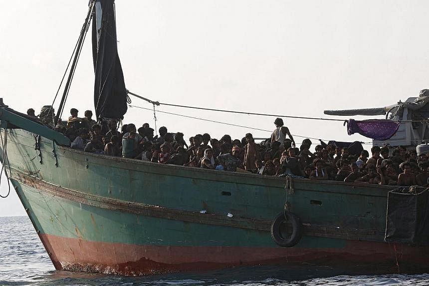 Migrants are seen aboard a boat tethered to a Thai navy vessel, in waters near Koh Lipe island, on May 16, 2015. Myanmar said on Wednesday that it was “ready to provide humanitarian assistance” to boatpeople, in its most conciliatory comments yet