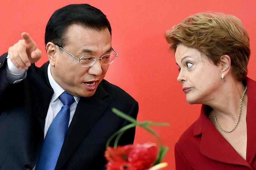 China's Prime Minister Li Keqiang (left) and Brazilian President Dilma Rousseff speak during the signing of agreements at the Planalto Palace in Brasilia on May 19, 2015. -- PHOTO: AFP