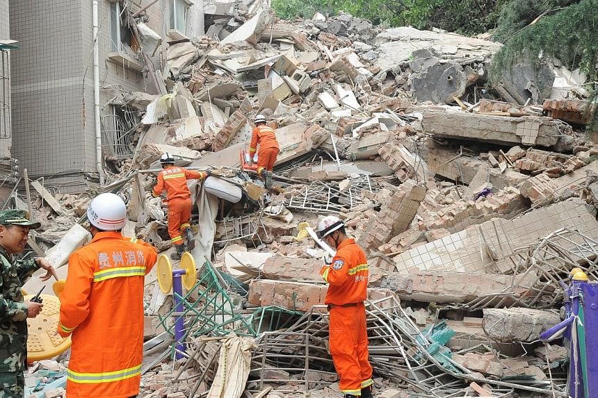 Rescuers look for survivors in the ruins of a collapsed nine-storey residential apartment in Guiyang, south-west China's Guizhou province on May 20, 2015.&nbsp;At least 15 people were believed to be missing on Wednesday afterthe building collapsed du