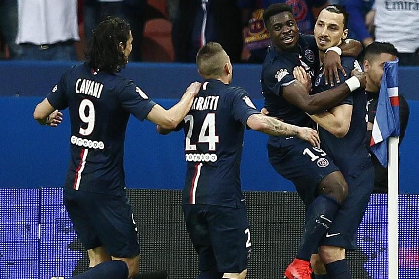 Paris St Germain's Zlatan Ibrahimovic (right) celebrates with Paris St Germain's Serge Aurier (second-right) after scoring the 2-0 goal during the French Ligue 1 soccer match between Paris Saint-Germain (PSG) and EA Guingamp at the Parc des Princes s