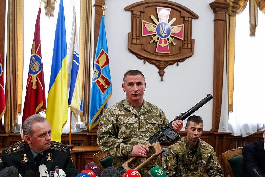 A Ukrainian soldier shows a weapon allegedly belonging to Russian servicemen captured by Ukrainian forces, during a briefing in Kiev, Ukraine on May 18, 2015. The two suspected Russian soldiers who were captured by Ukraine have been charged with invo