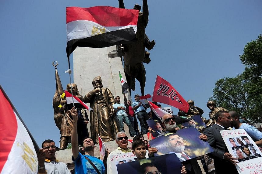Pro-Islamist demonstrators hold Egyptian flags and posters of former President Mohamed Mursi during a protest in support of him at the courtyard of Fatih mosque in Istanbul, Turkey, May 17, 2015.&nbsp;Egypt appointed judge Ahmed el-Zend, a fierce cri