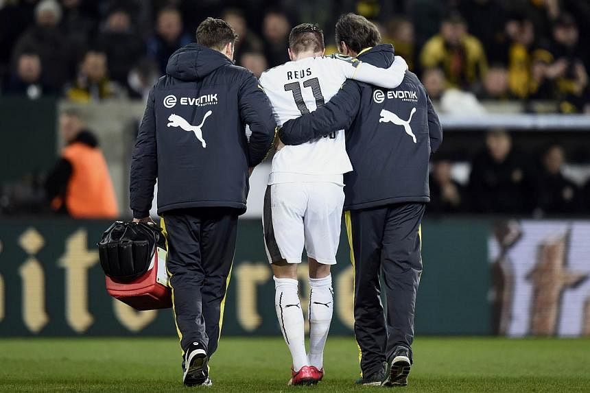 Dortmund's striker Marco Reus (centre) is helped to leave the pitch after being injured during the German Football Cup DFB Pokal round of 16 game between Dynamo Dresden and Borussia Dortmund on March 3, 2015 in Dresden, eastern Germany. -- PHOTO: AFP