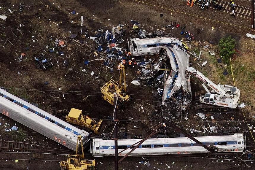 Emergency workers look through the remains of a derailed Amtrak train in Philadelphia, Pennsylvania, in this file photo taken May 13. -- PHOTO: REUTERS