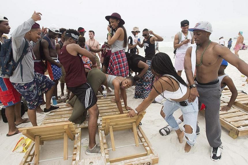 People gather to twerk during spring break festivities in Panama City Beach, Florida on March 12, 2015. "Twerking", "hashtag" and "facetime" are among 6,500 brash new entries in the Scrabble dictionary that reflect the Internet age but have left trad