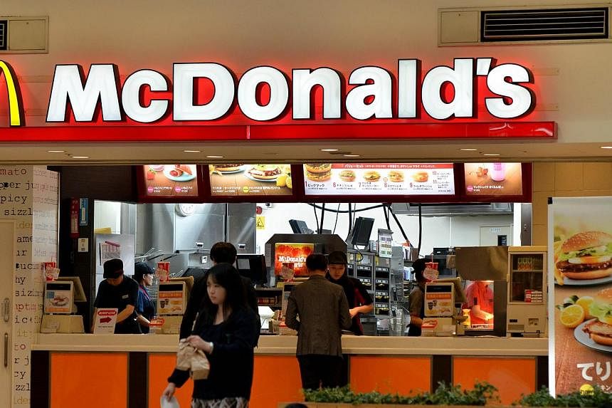 Customers buy meals at a McDonald's restaurant in Tokyo on April 16, 2015. McDonald's Japan unveiled a limited revamp to its menu and pricing on Thursday, May 21, as the under-fire fast food chain fights to restore its reputation. -- PHOTO: AFP
