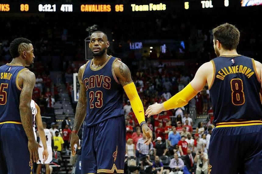 LeBron James (centre), J.R. Smith (left) and Matthew Dellavedova (right) of the Cleveland Cavaliers react after Iman Shumpert drew a foul in the second half against the Atlanta Hawks during Game One of the Eastern Conference Finals of the 2015 NBA Pl