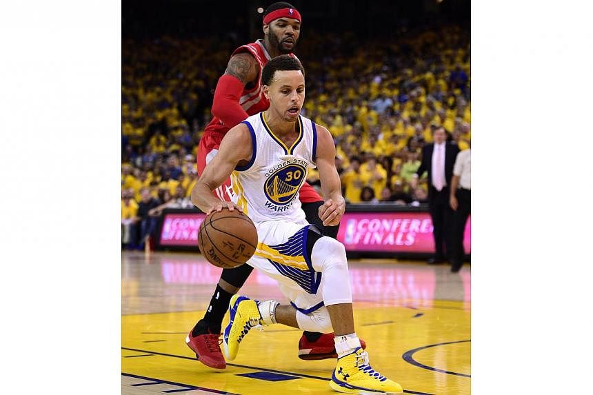Golden State Warriors guard Stephen Curry (centre) dribbles by Houston Rockets forward Josh Smith (left) during the second half of their NBA Western Conference Finals, Game One at Oracle Arena in Oakland, California, USA on May 19, 2015.-- PHOTO: EPA