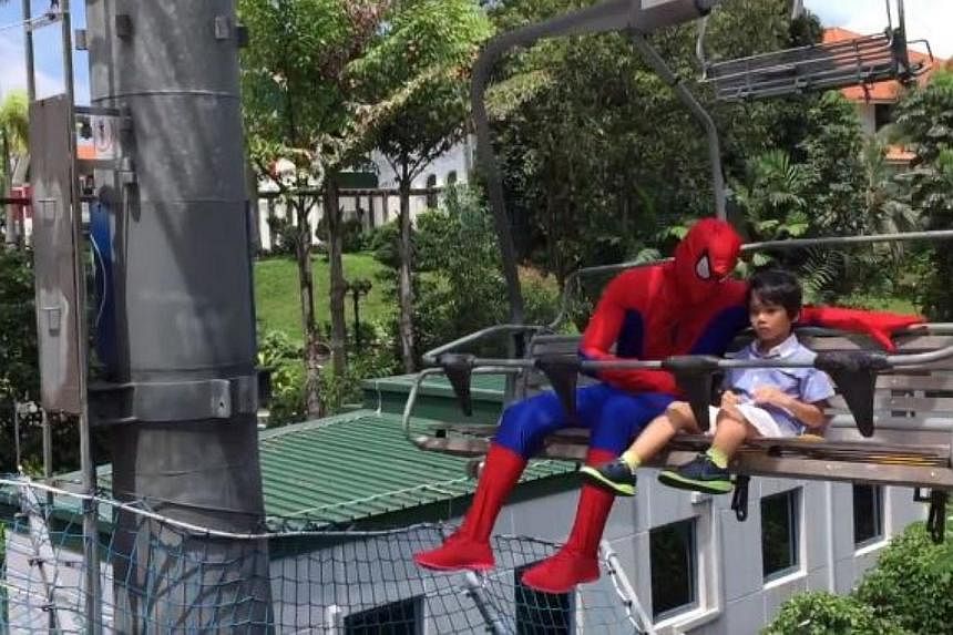 Mr Suhaimi Latiff had to train for six months as the Spider-Man costume is skin-tight, and the full face mask is not easy to breathe through. "Spider-Man" and Zeyrian even went on a trip to Sentosa. -- SCREEN GRAB FROM VIDEO / JULIA JEMANGIN &nbsp;