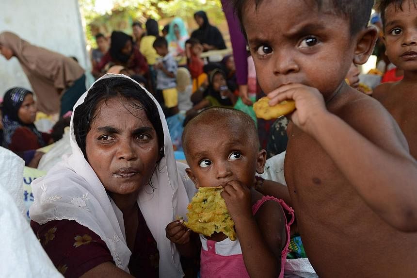 Rescued Rohingya women and children are provided with food by Indonesian residents in the compound of a mosque in Julok district, Aceh province, on May 20, 2015, after they were rescued by Indonesian fishermen off the waters of the eastern coast of A