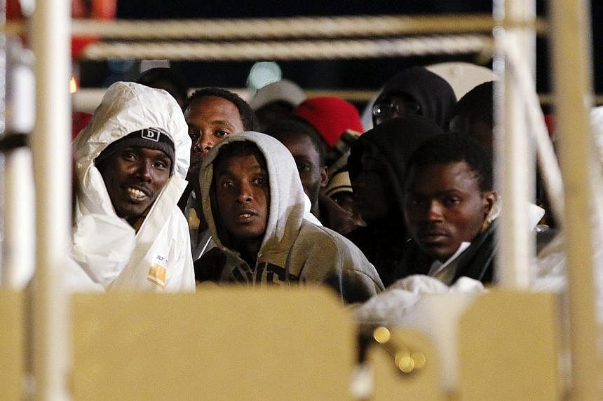 Migrants wait aboard a navy ship before being disembarked in the Sicilian harbour of Augusta on March 4, 2015.&nbsp;The arrest in Italy of a terror suspect posing as a boat migrant has fuelled nightmare scenarios of Islamic militant infiltration of E
