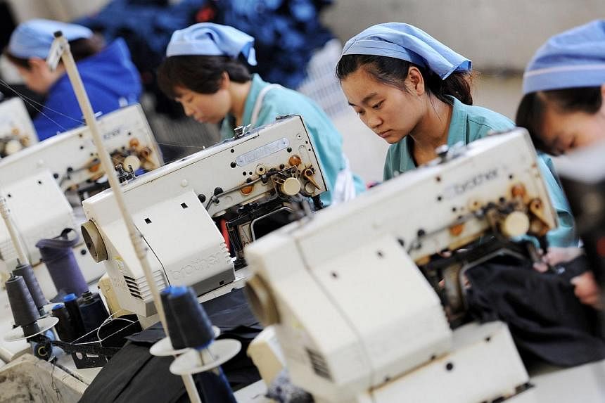 Workers producing clothes in a factory in Huaibei, east China's Anhui province, on May 19, 2015. China's factory activity contracted for the third straight month in May, which together with a lacklustre performance from Japan and alarmingly weak expo