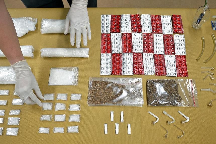 A CNB officer at the CNB office at Cantonment Road arranging the drugs which were obtained during a CNB drug bust.&nbsp;A Singaporean man suspected of drug trafficking was arrested on Wednesday in an operation that seized more than $239,000 in drugs.